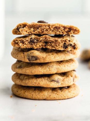 A stack of pumpkin chocolate chip cookies on a marble surface.