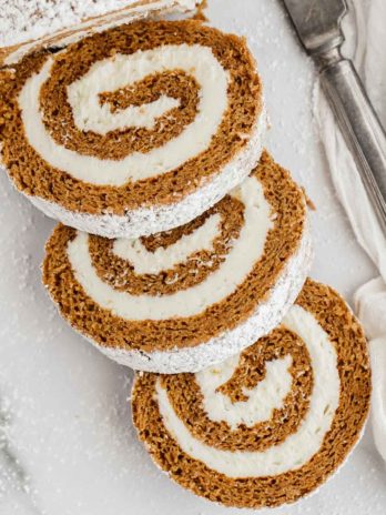 A sliced pumpkin roll dusted with powdered sugar.