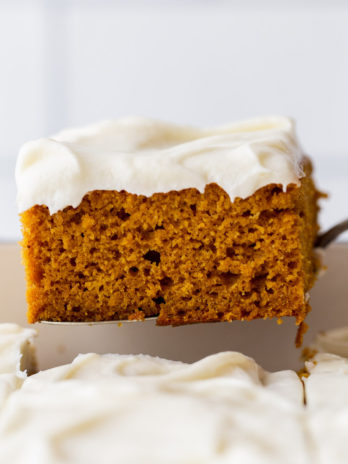 A single piece of cake being removed from the baking dish showing the cake and frosting layers.